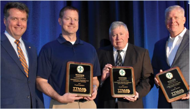 Four individuals stand together, proudly displaying award plaques recognizing their achievements in emergency medical services.